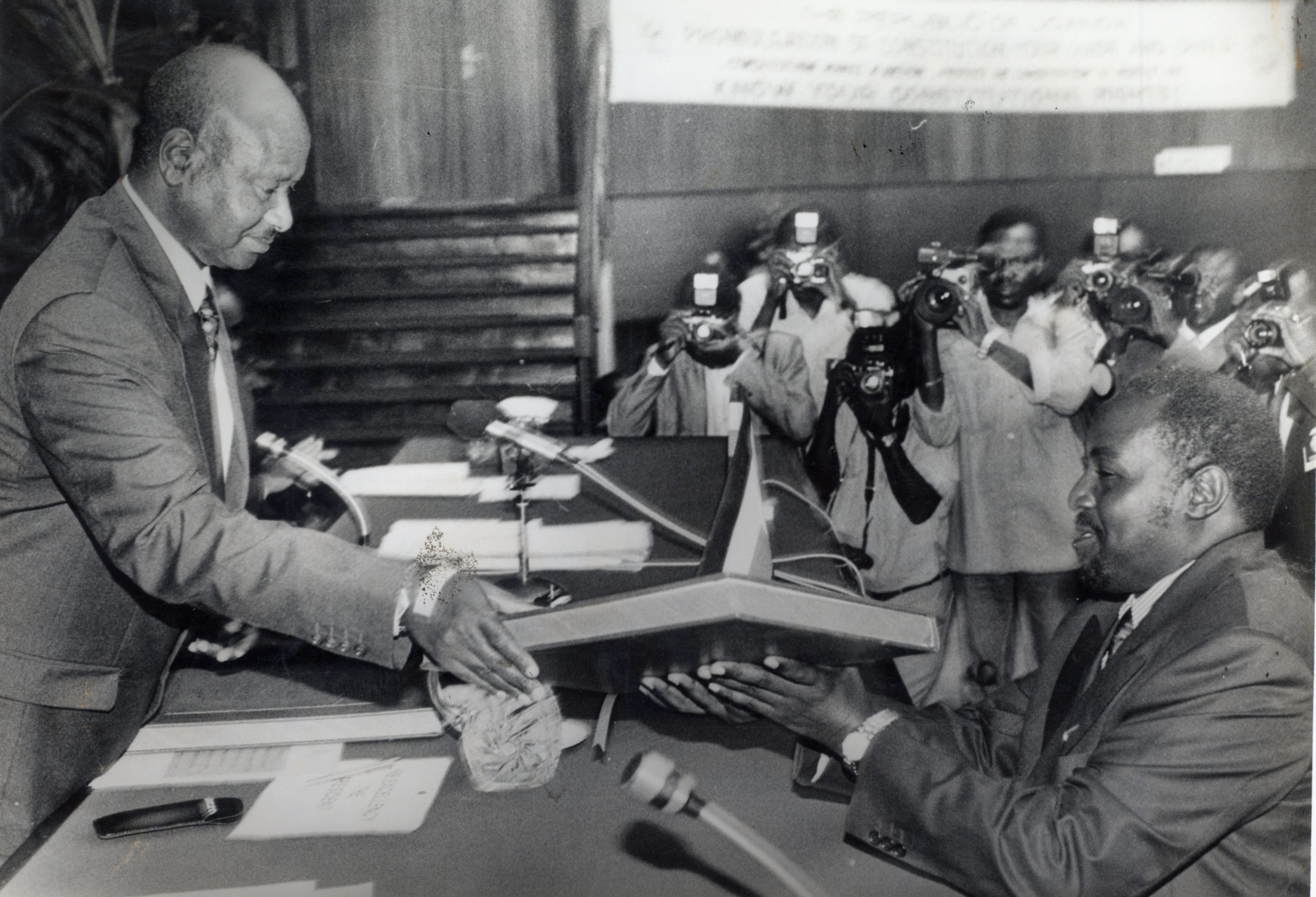 President Museveni gives a copy of the new Constitution to Hajji Moses Kigongo immediately after receiving three copies of it on October 8, 1995.