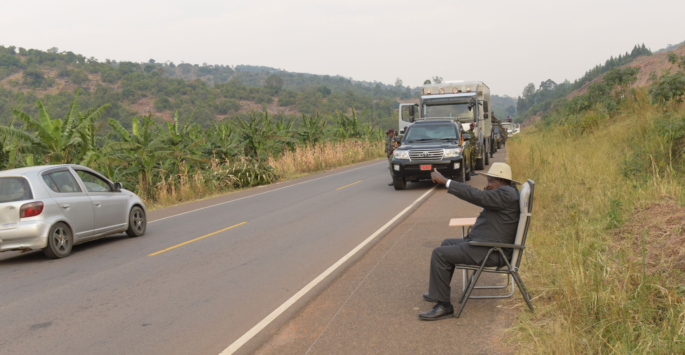 President_Museveni_takes_a_phone_callat_the_road_side_in_Kyeirumba_as_he_acknowledges_cheers_from_passersby-12.07.16.jpg