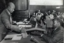 President Yoweri Museveni gives a copy of the new Constitution to Haji Moses Kigongo, the Speaker of Parliament immediately after receiving 3 copies of it 08.10.1995 2.jpg