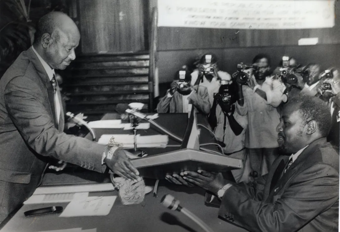 President Yoweri Museveni gives a copy of the new Constitution to Haji Moses Kigongo, the Speaker of Parliament immediately after receiving 3 copies of it 08.10.1995 2.jpg